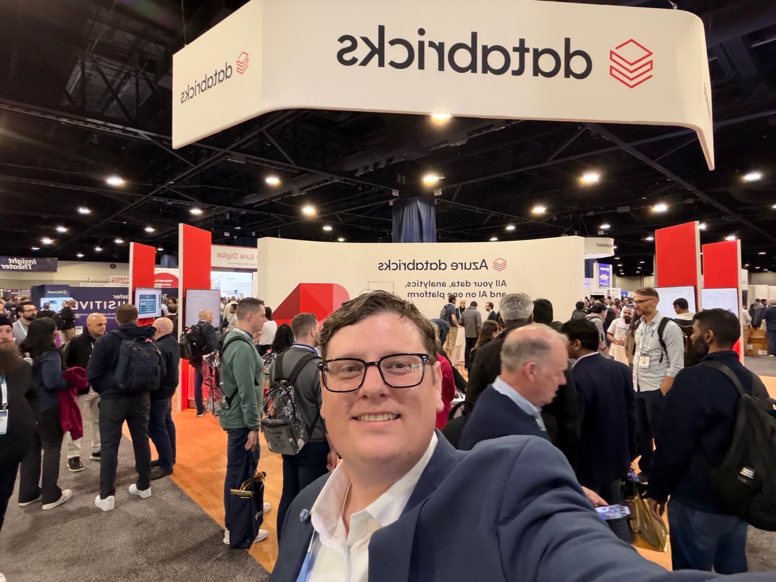 Zach at FabCon 26 in front of the Databricks booth